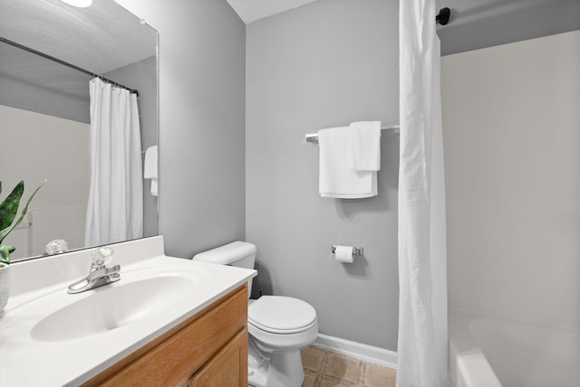 bathroom featuring toilet, baseboards, and vanity