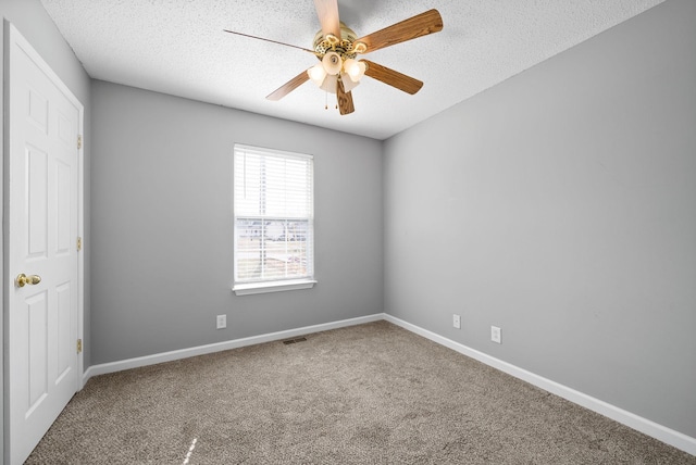 spare room with carpet, visible vents, a textured ceiling, and baseboards