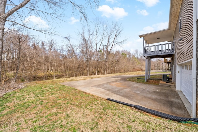 view of yard with cooling unit and concrete driveway