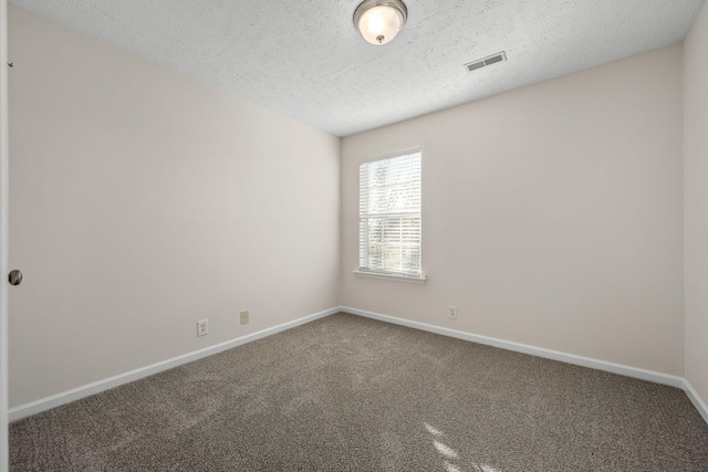 carpeted empty room with visible vents, baseboards, and a textured ceiling