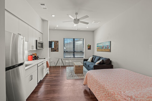 bedroom featuring ceiling fan, stainless steel fridge, dark hardwood / wood-style flooring, and sink