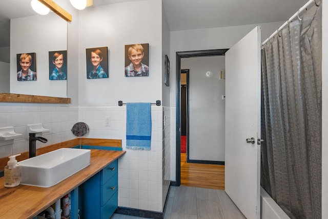 bathroom featuring vanity and tile walls