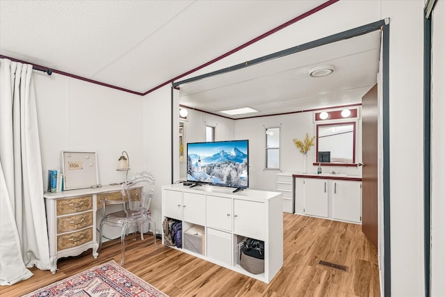 home office with lofted ceiling, a textured ceiling, and light wood-type flooring