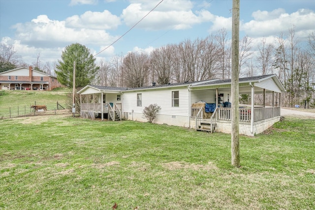 back of property with a lawn and a porch