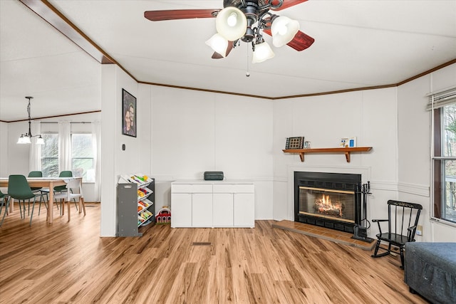 living area with ornamental molding, a healthy amount of sunlight, and light hardwood / wood-style floors