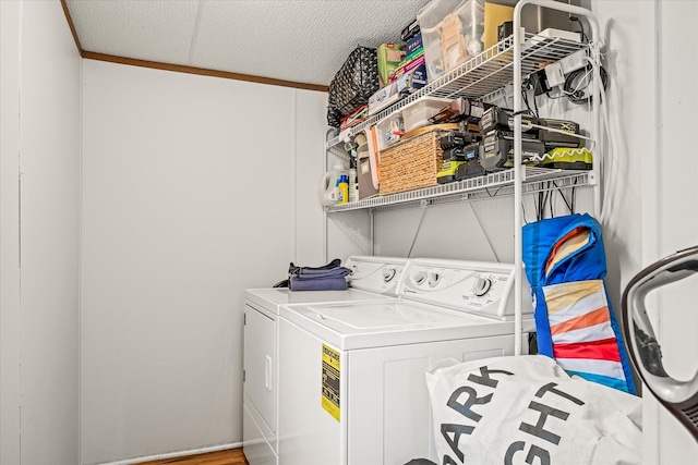 clothes washing area featuring crown molding and washer and dryer