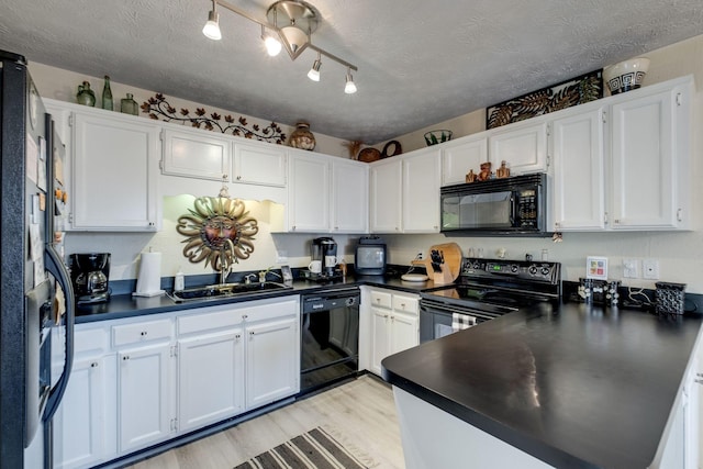 kitchen featuring white cabinets, sink, a textured ceiling, and black appliances