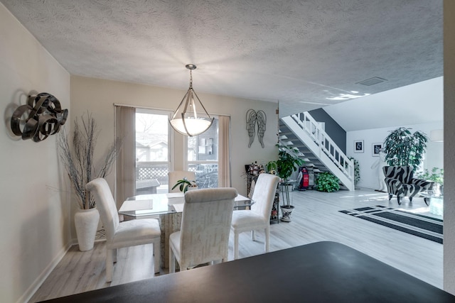 dining space featuring hardwood / wood-style flooring and a textured ceiling