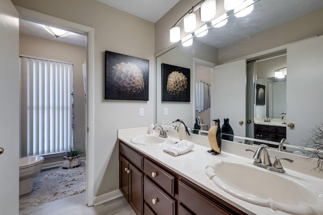 bathroom featuring vanity, wood-type flooring, and toilet