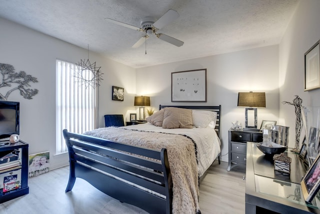 bedroom featuring a textured ceiling, light hardwood / wood-style floors, and ceiling fan