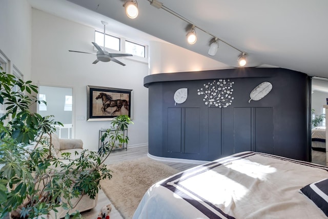 bedroom featuring rail lighting and wood-type flooring