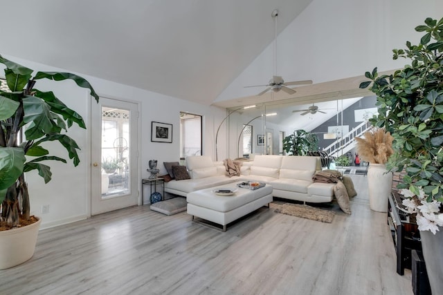 living room with high vaulted ceiling and light hardwood / wood-style flooring