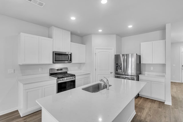 kitchen featuring white cabinetry, an island with sink, stainless steel appliances, and sink