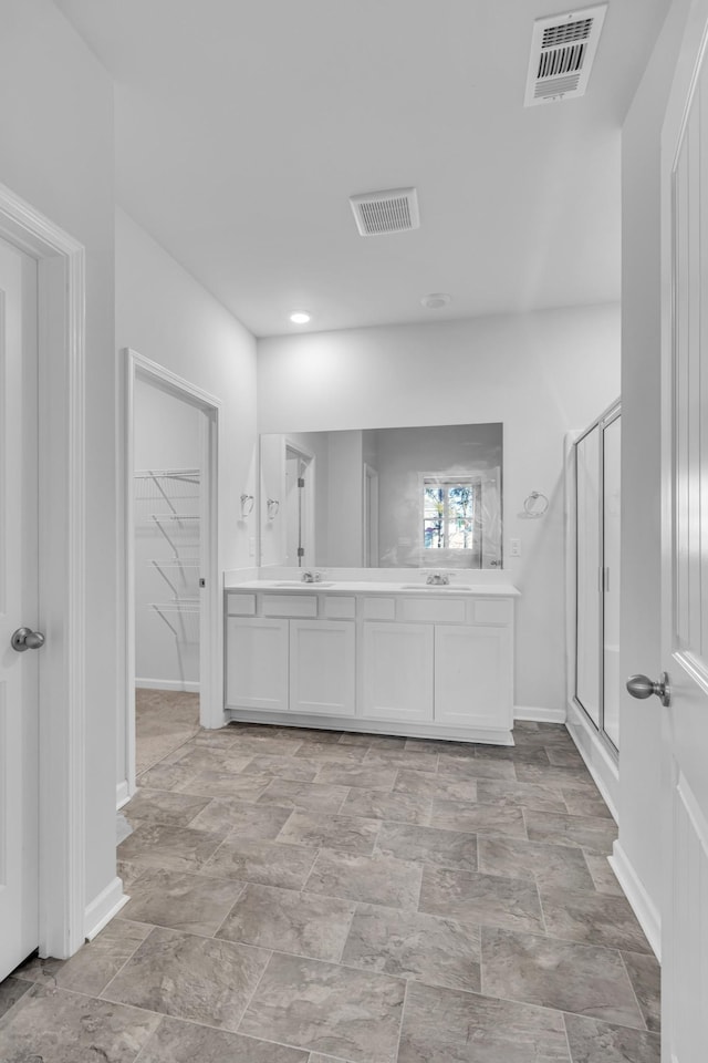 bathroom featuring vanity and an enclosed shower