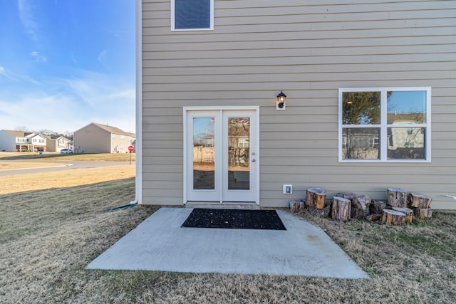 entrance to property with a lawn and a patio