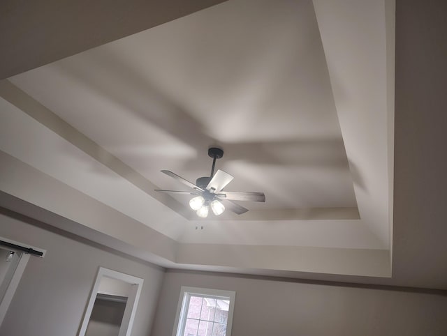 details with ceiling fan and a tray ceiling