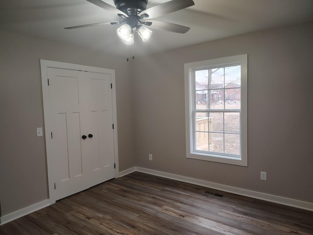 spare room with ceiling fan and dark hardwood / wood-style floors