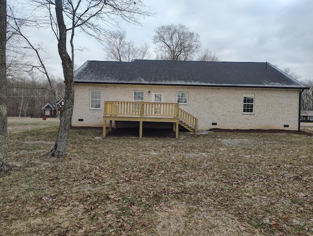 back of house featuring a wooden deck and a yard