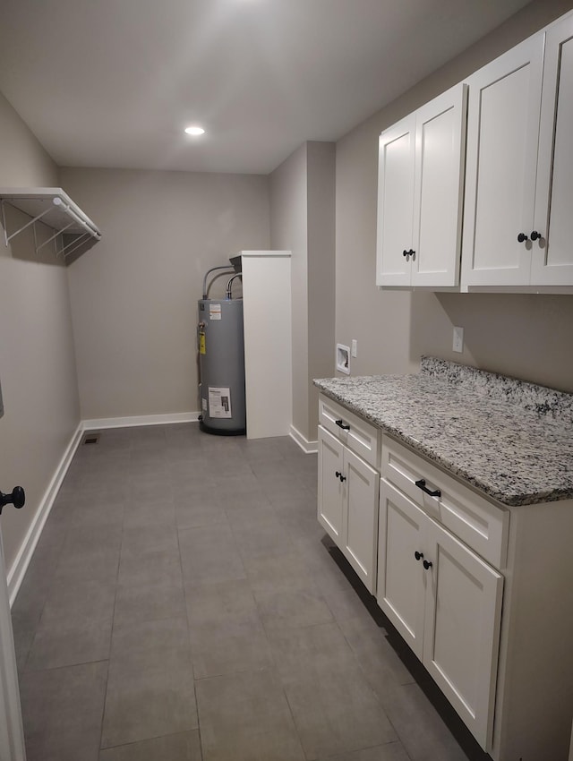 laundry room with cabinets, hookup for a washing machine, and water heater