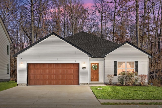 ranch-style home with a garage and a yard