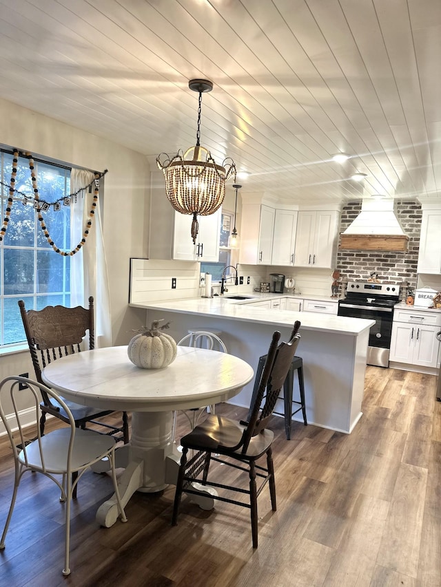 dining area featuring sink, a notable chandelier, wooden ceiling, and light wood-type flooring