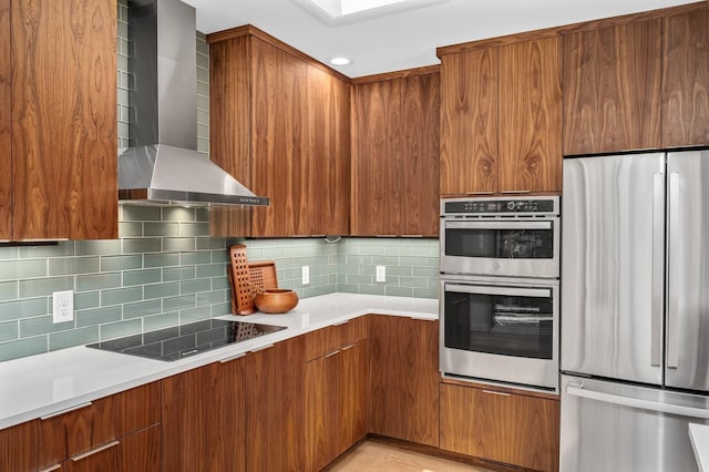 kitchen featuring stainless steel appliances, wall chimney range hood, and decorative backsplash