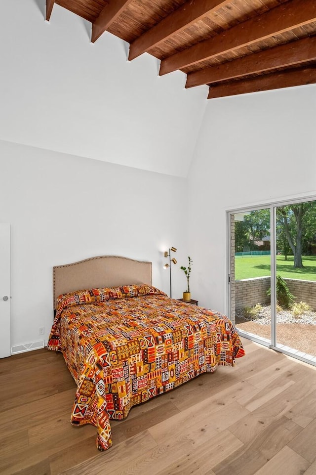 bedroom with beamed ceiling, high vaulted ceiling, hardwood / wood-style floors, and wood ceiling