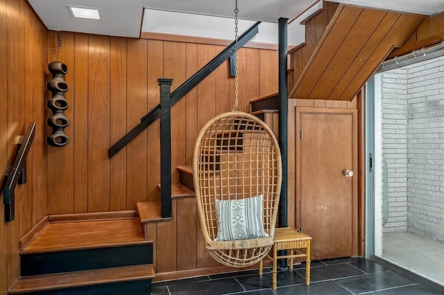 interior space with wooden walls and dark tile patterned floors