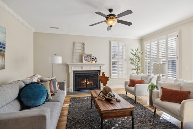 living room featuring hardwood / wood-style flooring, crown molding, and ceiling fan