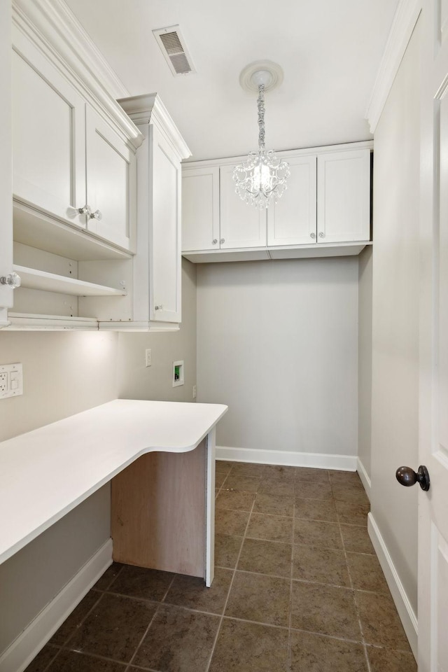 clothes washing area with cabinets, ornamental molding, hookup for a washing machine, and an inviting chandelier