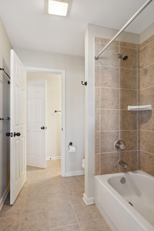 bathroom featuring toilet and tiled shower / bath