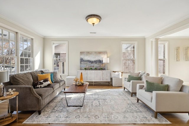 living room with dark wood-type flooring, ornamental molding, and decorative columns