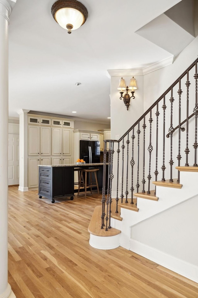 stairs with crown molding and hardwood / wood-style floors