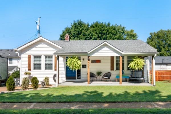 ranch-style house with a front lawn and a patio