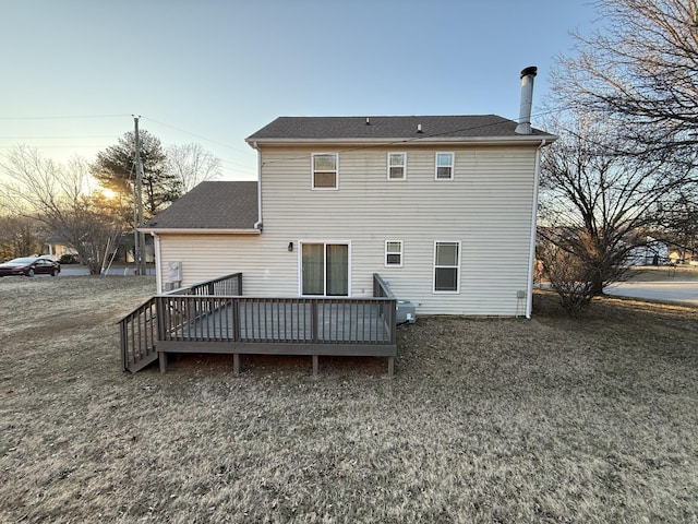 back house at dusk featuring a wooden deck