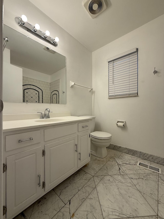 bathroom featuring vanity, toilet, and walk in shower