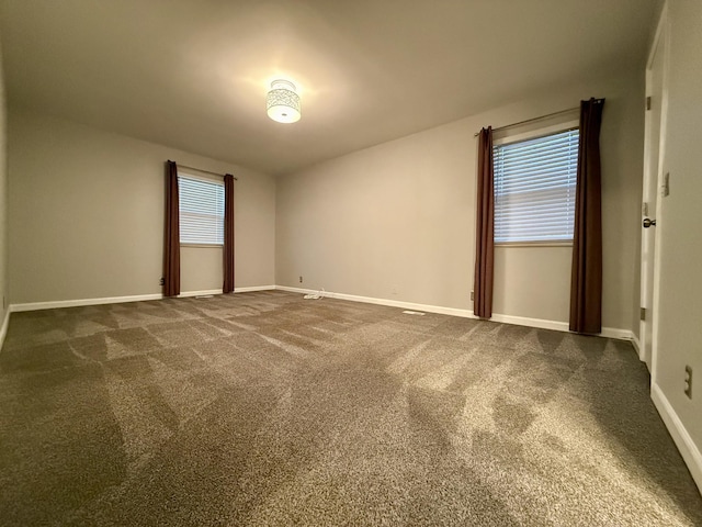 unfurnished room with dark colored carpet