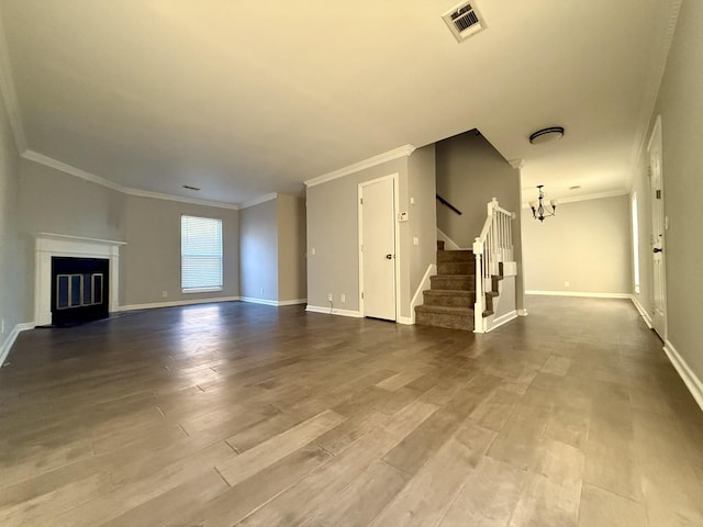 unfurnished living room featuring hardwood / wood-style flooring, ornamental molding, and a notable chandelier