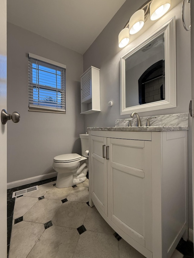 bathroom with tile patterned flooring, vanity, and toilet