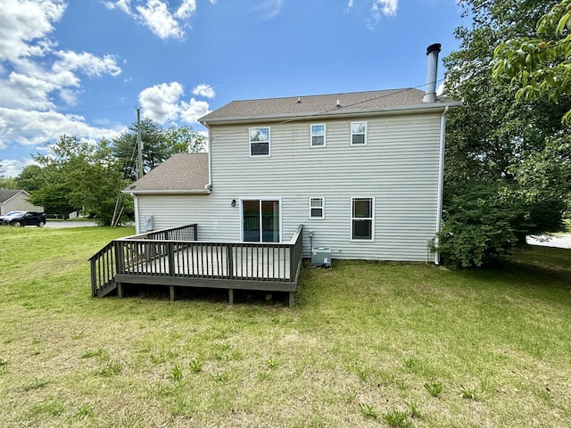 back of property with central AC, a wooden deck, a lawn, and a shingled roof