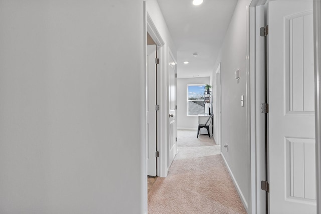 hallway featuring light colored carpet