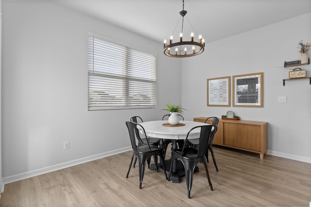 dining space with light hardwood / wood-style floors and a notable chandelier