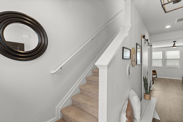 stairway with a barn door and hardwood / wood-style floors