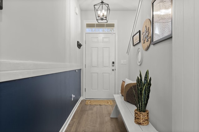 entryway with dark hardwood / wood-style floors and a notable chandelier