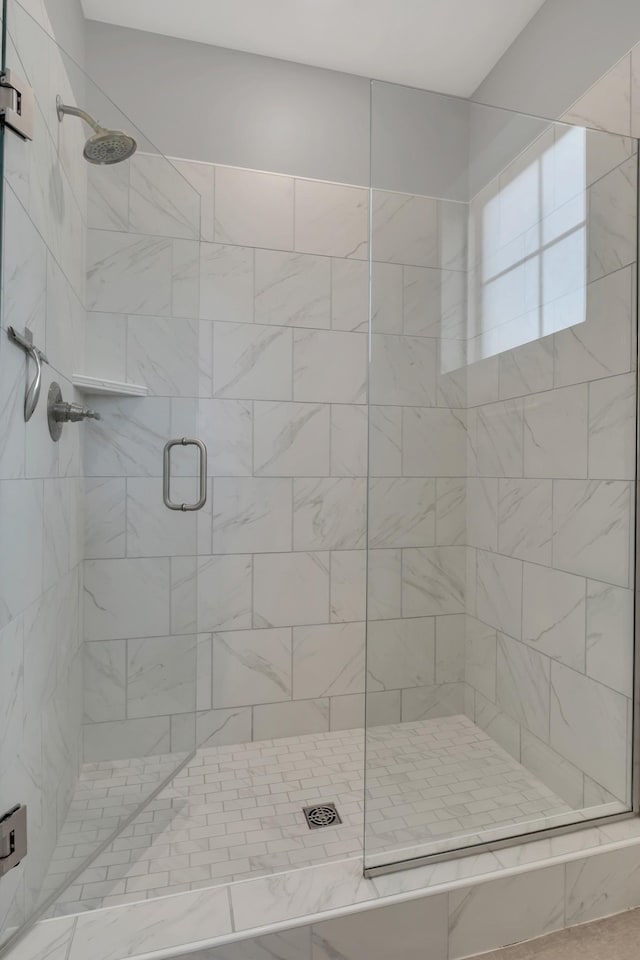 bathroom featuring a shower with door