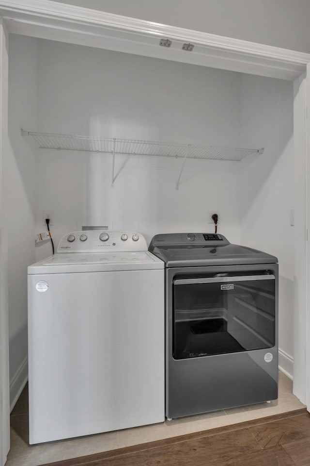 laundry area with hardwood / wood-style flooring and washing machine and clothes dryer