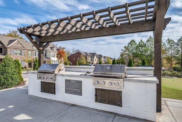 view of patio with area for grilling, a pergola, and exterior kitchen