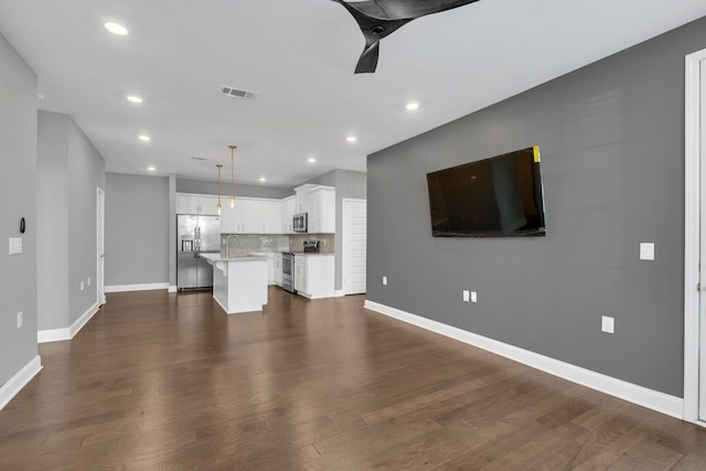 unfurnished living room with dark wood-type flooring and sink