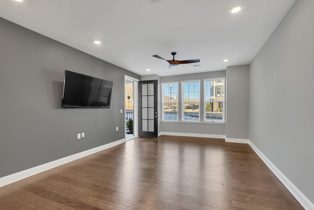 unfurnished living room featuring ceiling fan and dark hardwood / wood-style flooring