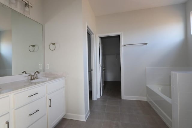 bathroom featuring tile patterned floors, vanity, and a bathing tub